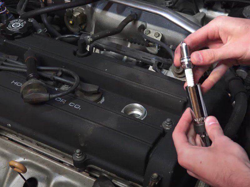 Photo of mobile mechanic replacing a car's spark plugs.